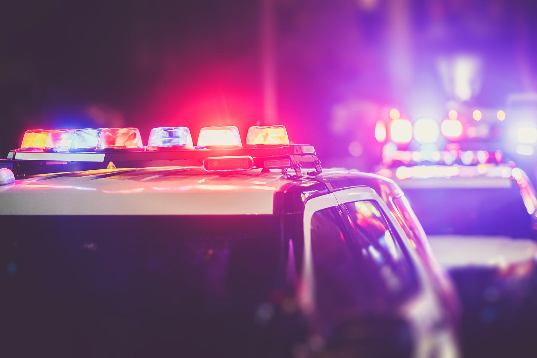 2 parked Police cars with their lights on at night